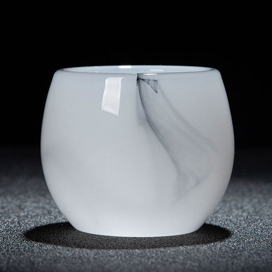 A small translucent white glass cup with a rounded shape, photographed on a dark textured surface against a black background. A white label is attached near the rim, and a text banner appears along the bottom with Chinese characters and dimensions.