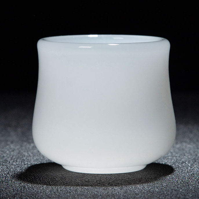 A white glass tea cup with a smooth matte finish, photographed against a dark background with a gray textured surface beneath it. A red and white text banner is visible at the bottom of the image displaying dimensions and capacity.