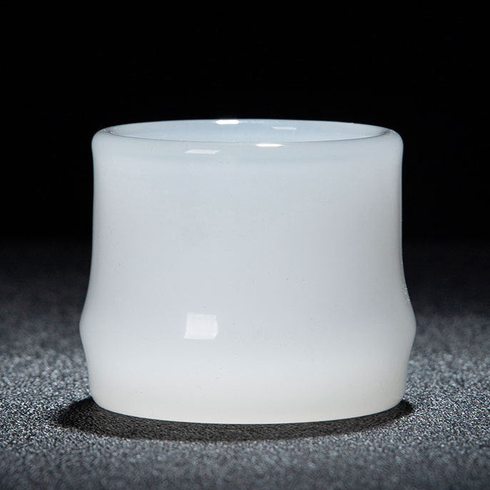 A white translucent glass cup with a smooth matte finish, photographed against a dark background. A red and white text banner is visible at the bottom with Chinese dimensions and capacity details.