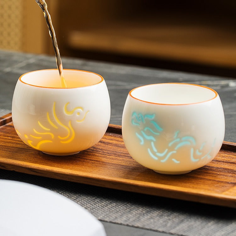 Tea being poured into phoenix and dragon jade porcelain cups