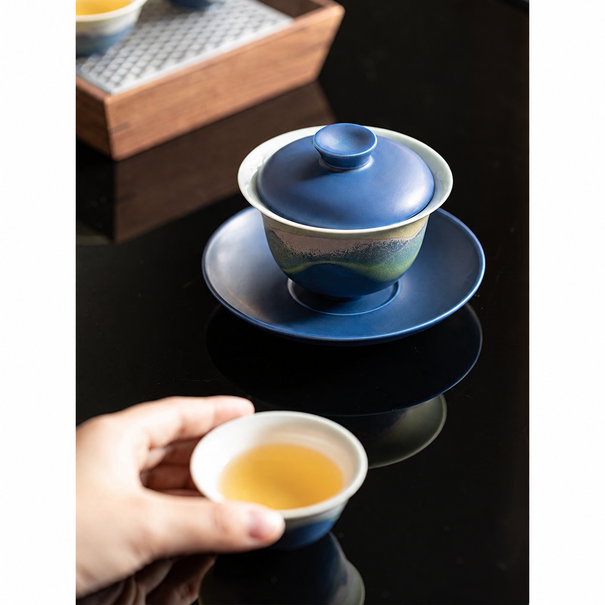 Blue mountain-glaze gaiwan with tea cup during a gongfu tea session