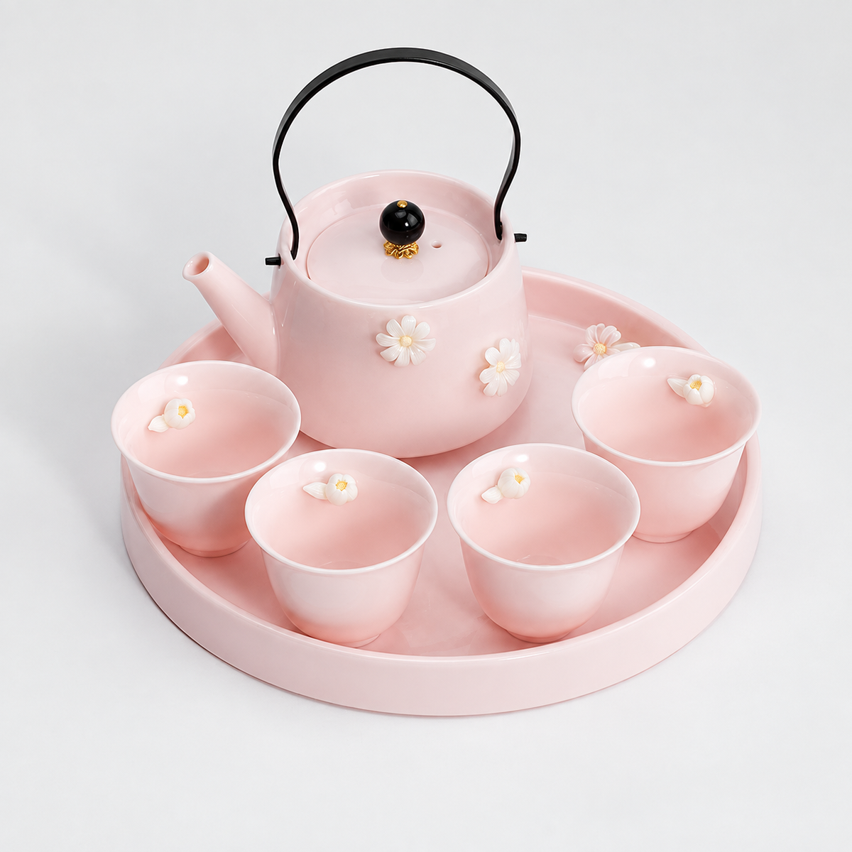 Blush pink floral tea set with teapot, four flared magnolia cups, and round tray